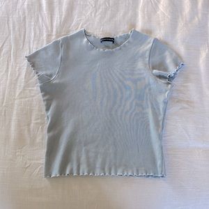 This a light blue, ruffled edge, cropped, shirt.